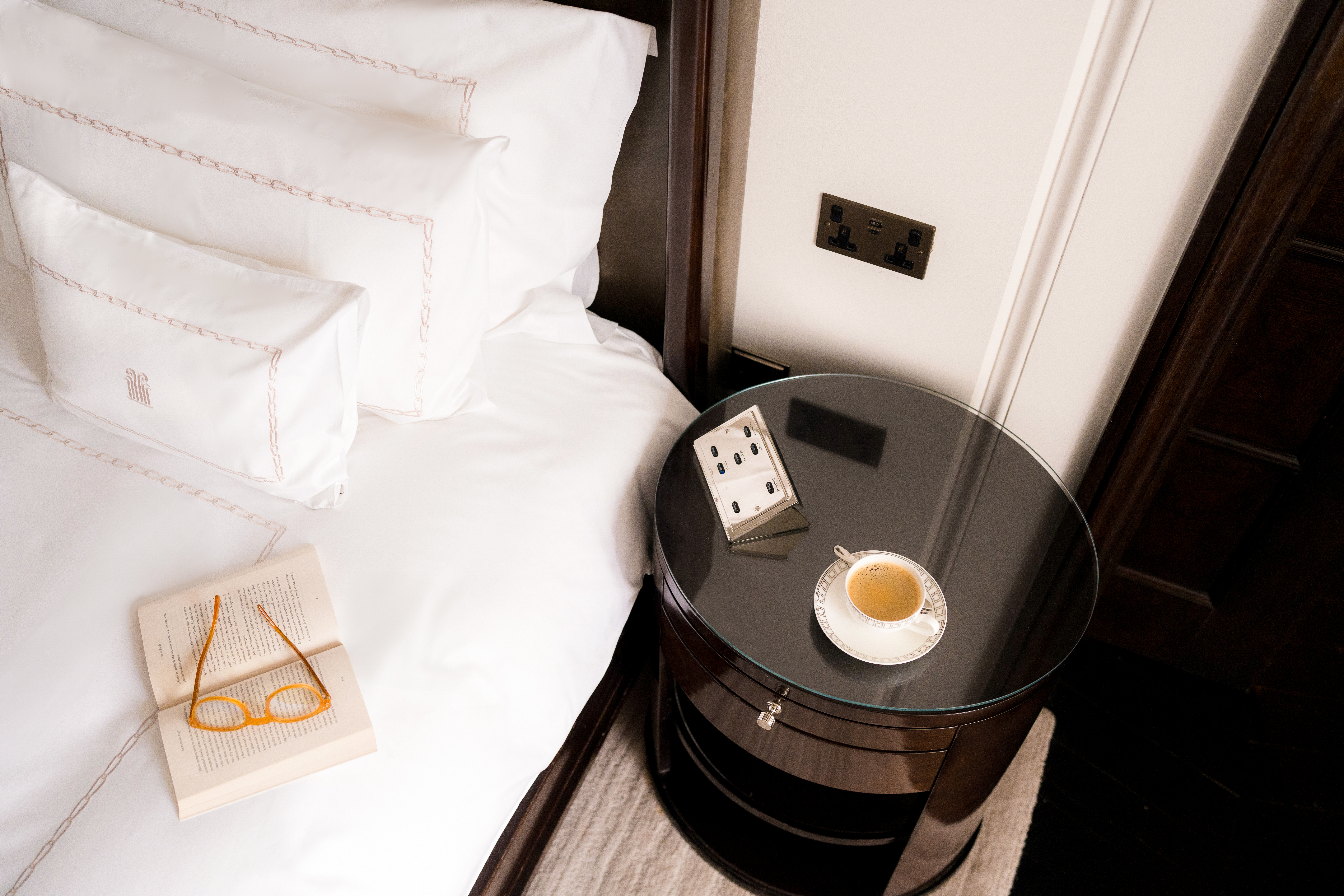 Detail of Actor's Penthouse bed with cup of coffee and power socket at Corinthia London luxury hotel near Trafalgar Square and Westminster