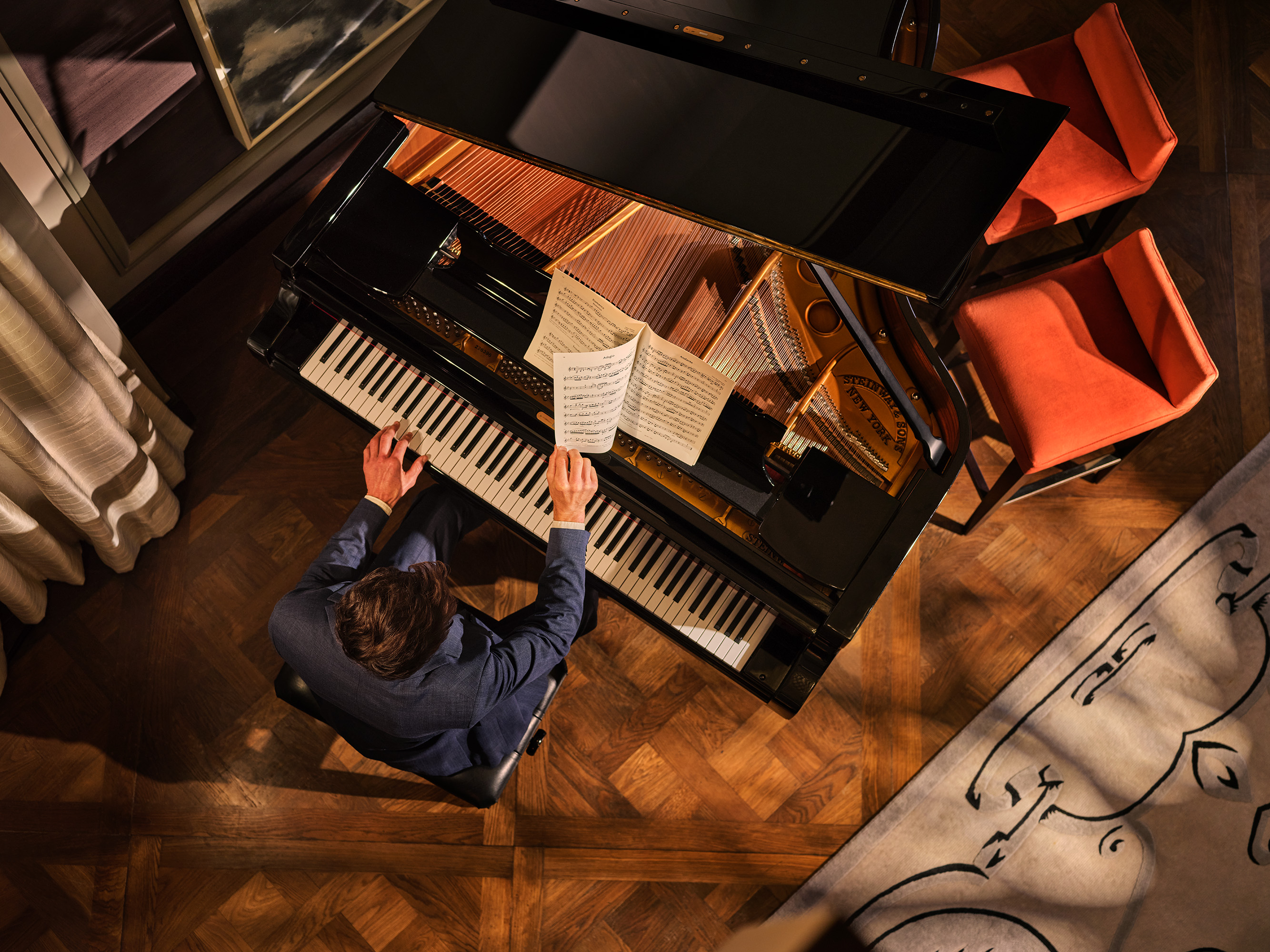 Man playing piano in Musicians Penthouse at Corinthia London luxury hotel near Trafalgar Square