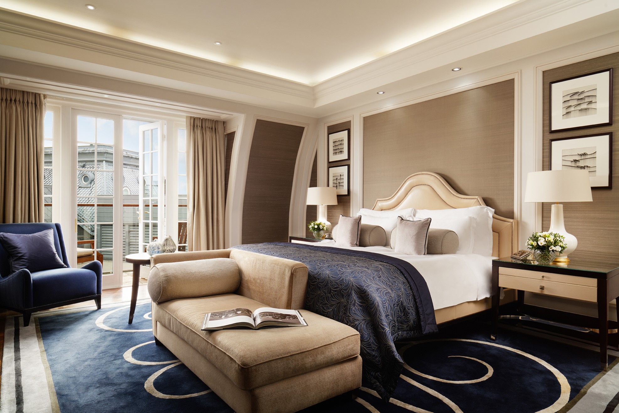 Penthouse suite bedroom at Corinthia London luxury hotel with large open windows showcasing London city views