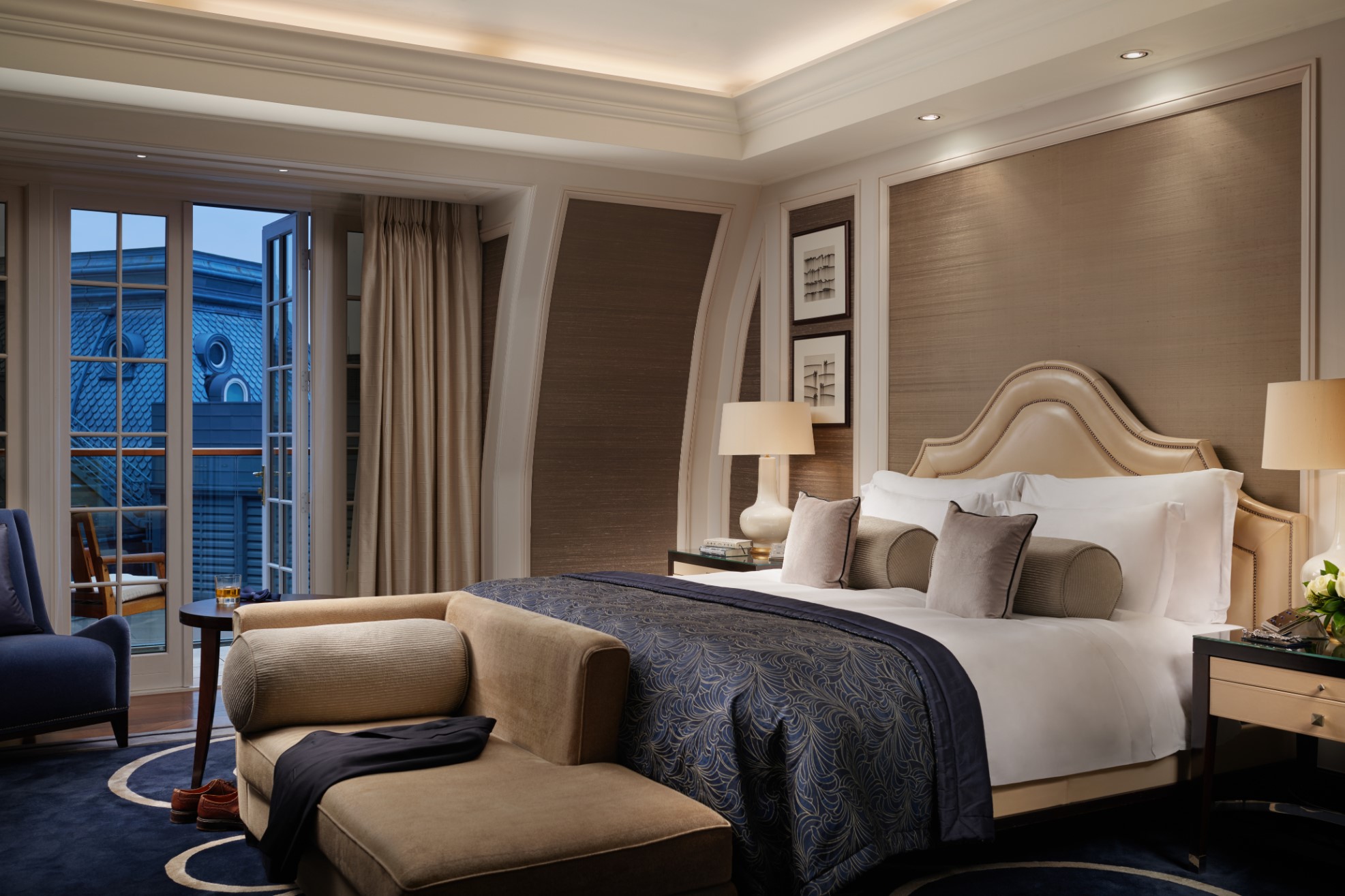 Musician's Penthouse bedroom at Corinthia London luxury hotel evening view showcasing bed and ambient lighting