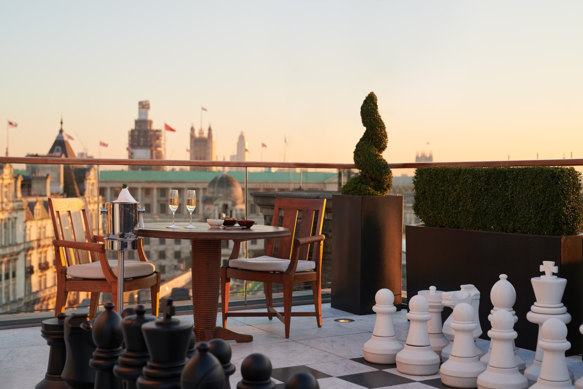 Whitehall Penthouse terrace at Corinthia London luxury hotel featuring giant chessboard dining table overlooking Westminster