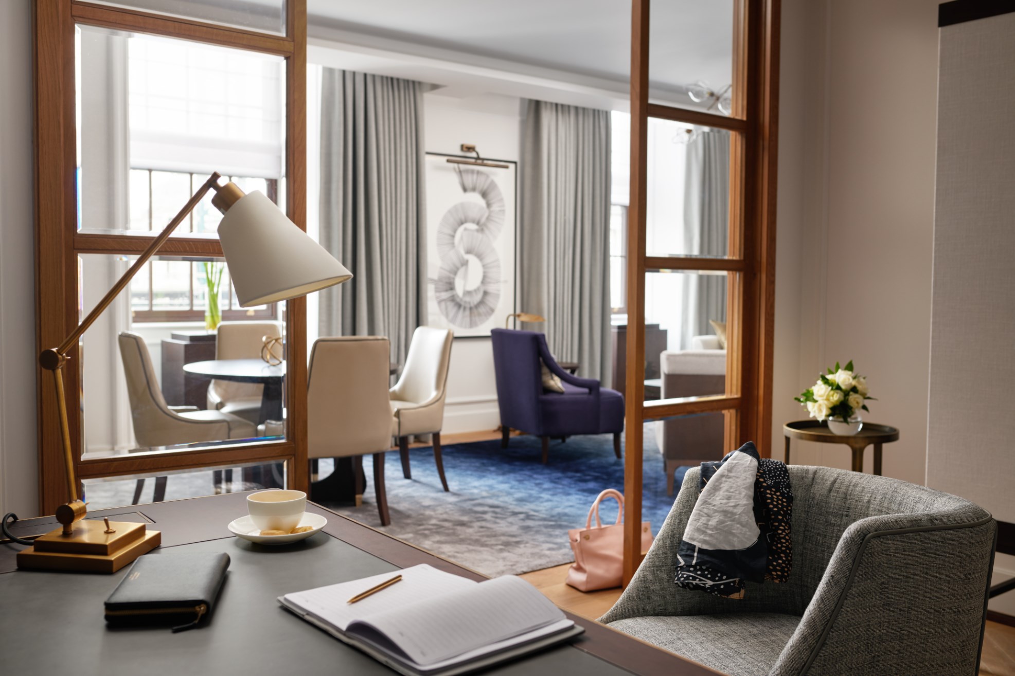 Desk with notebook and grey chair, with views into the dining area