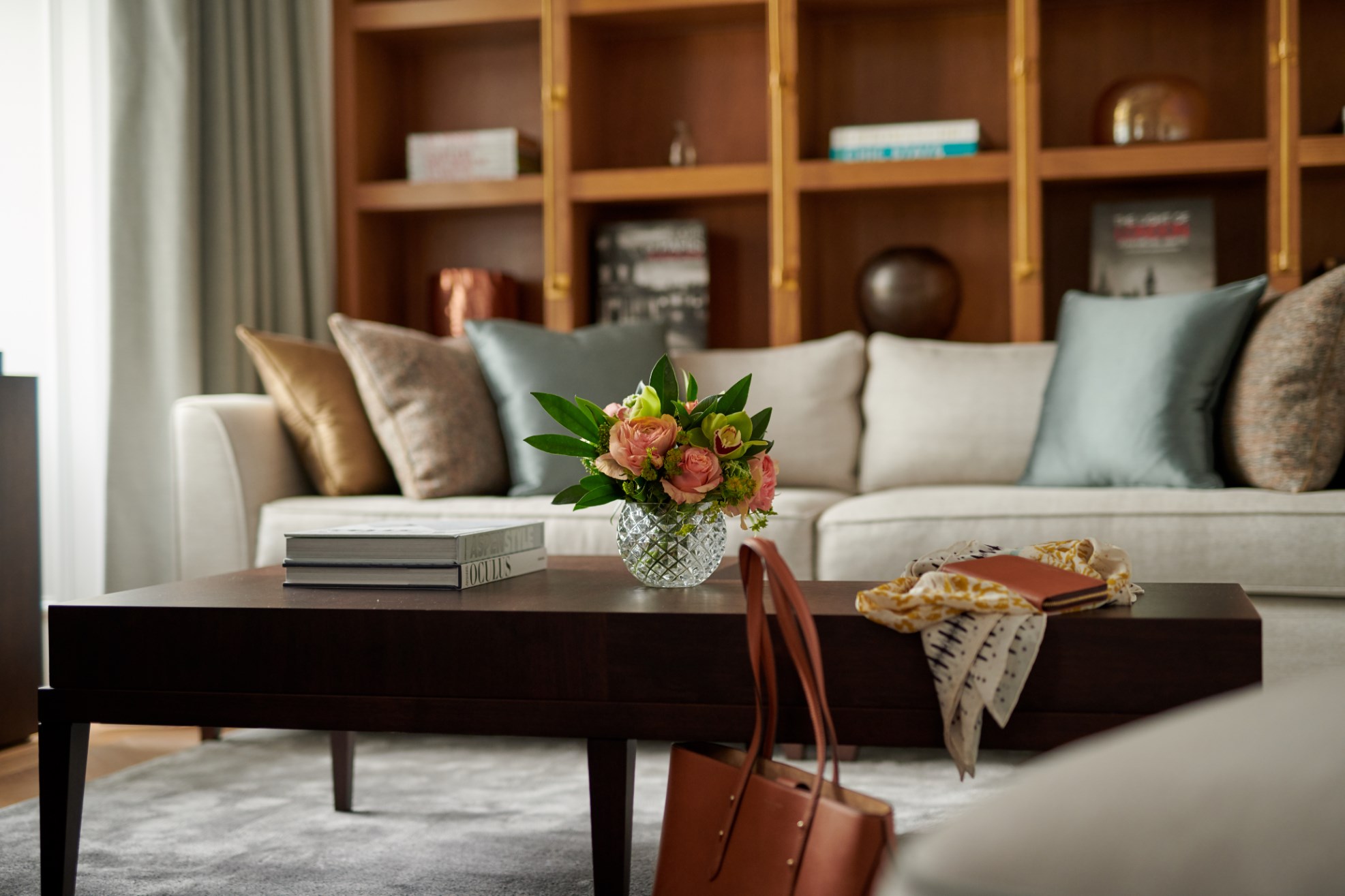 White sofa with colourful cushions next to a wooden table 