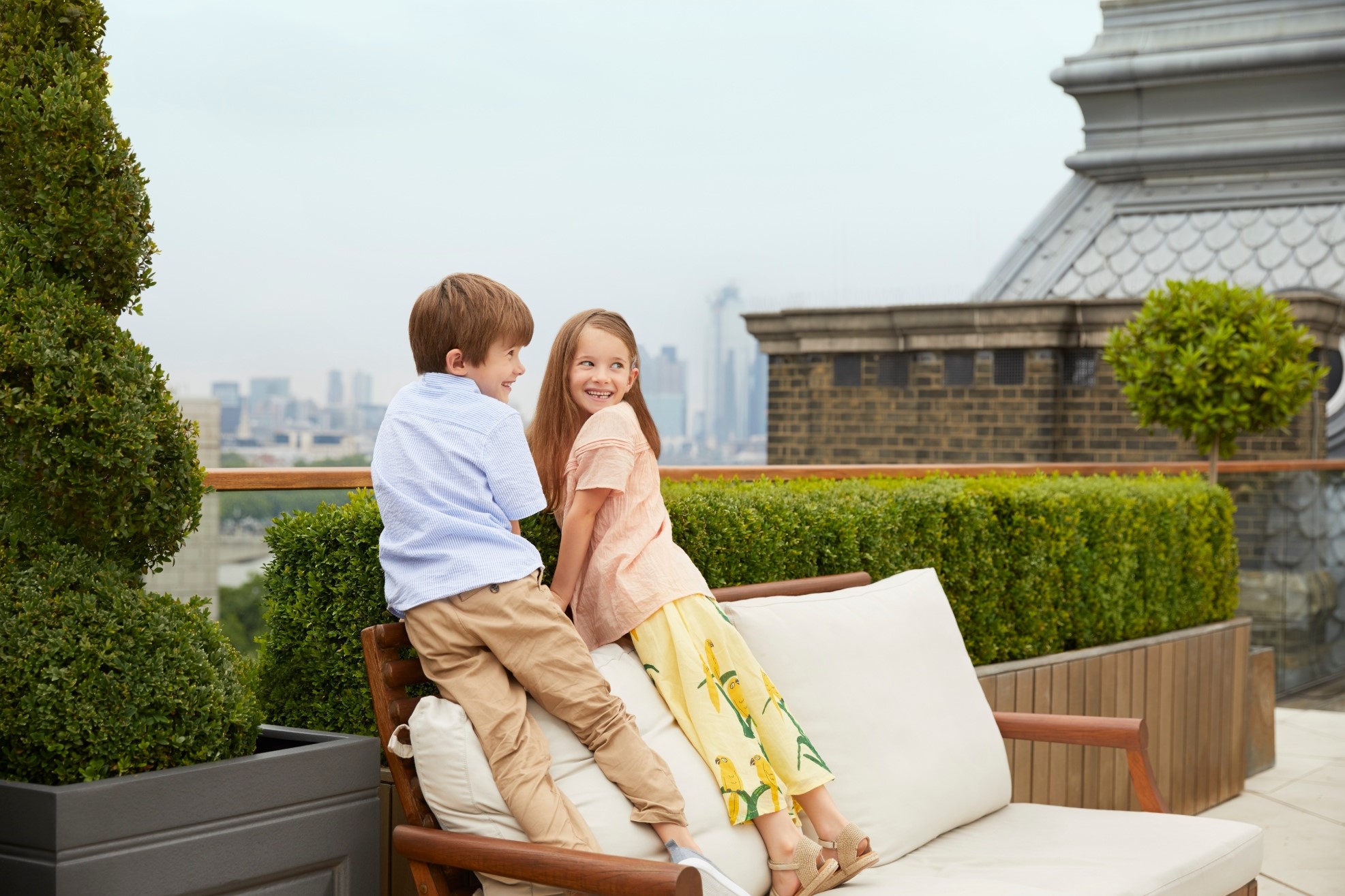Two kids on a terrace with views of London skyline