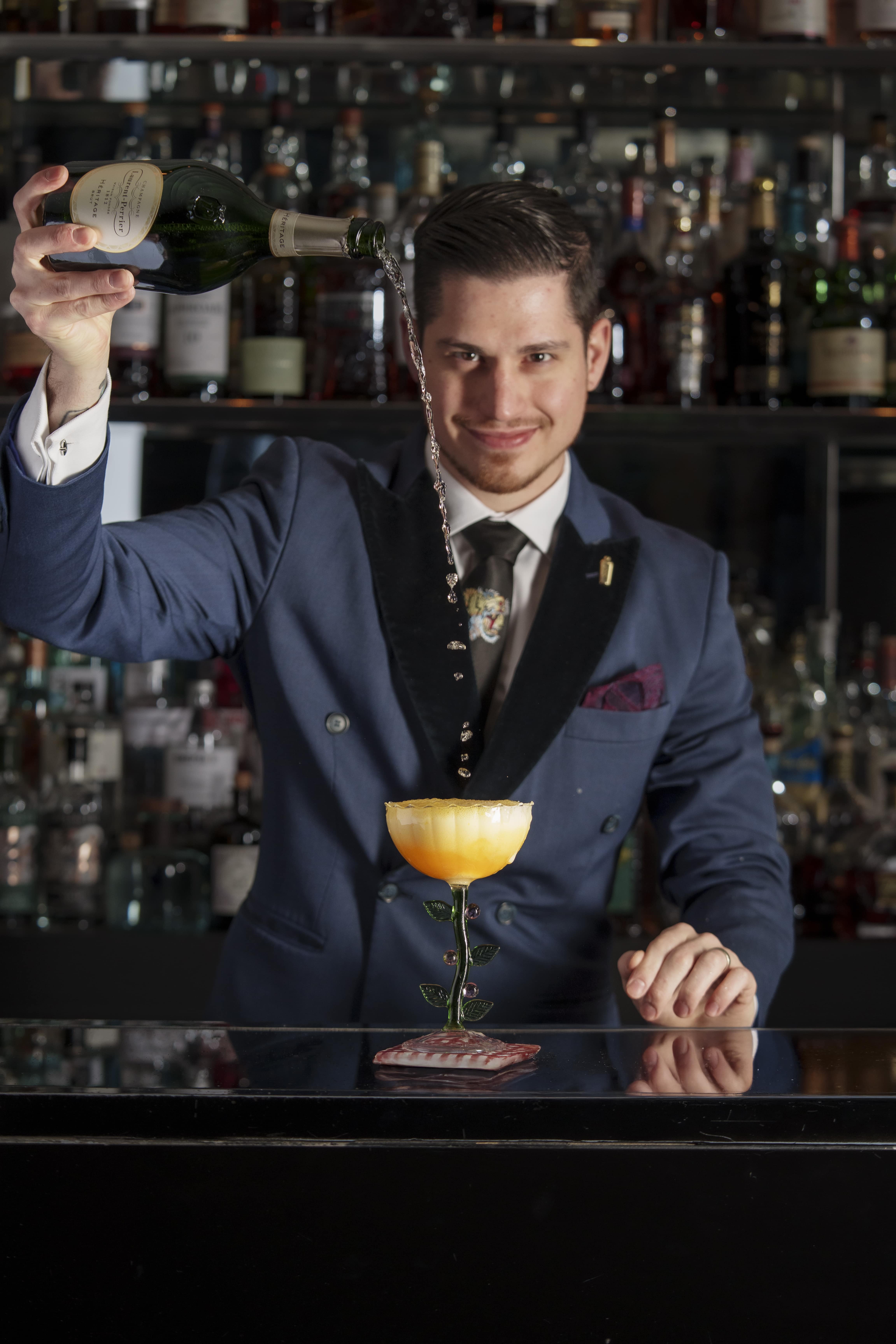 Head Mixologist of Velvet by Salvatore Calabrese expertly pouring a cocktail from The Pixel Book Menu, showcasing innovative mixology techniques