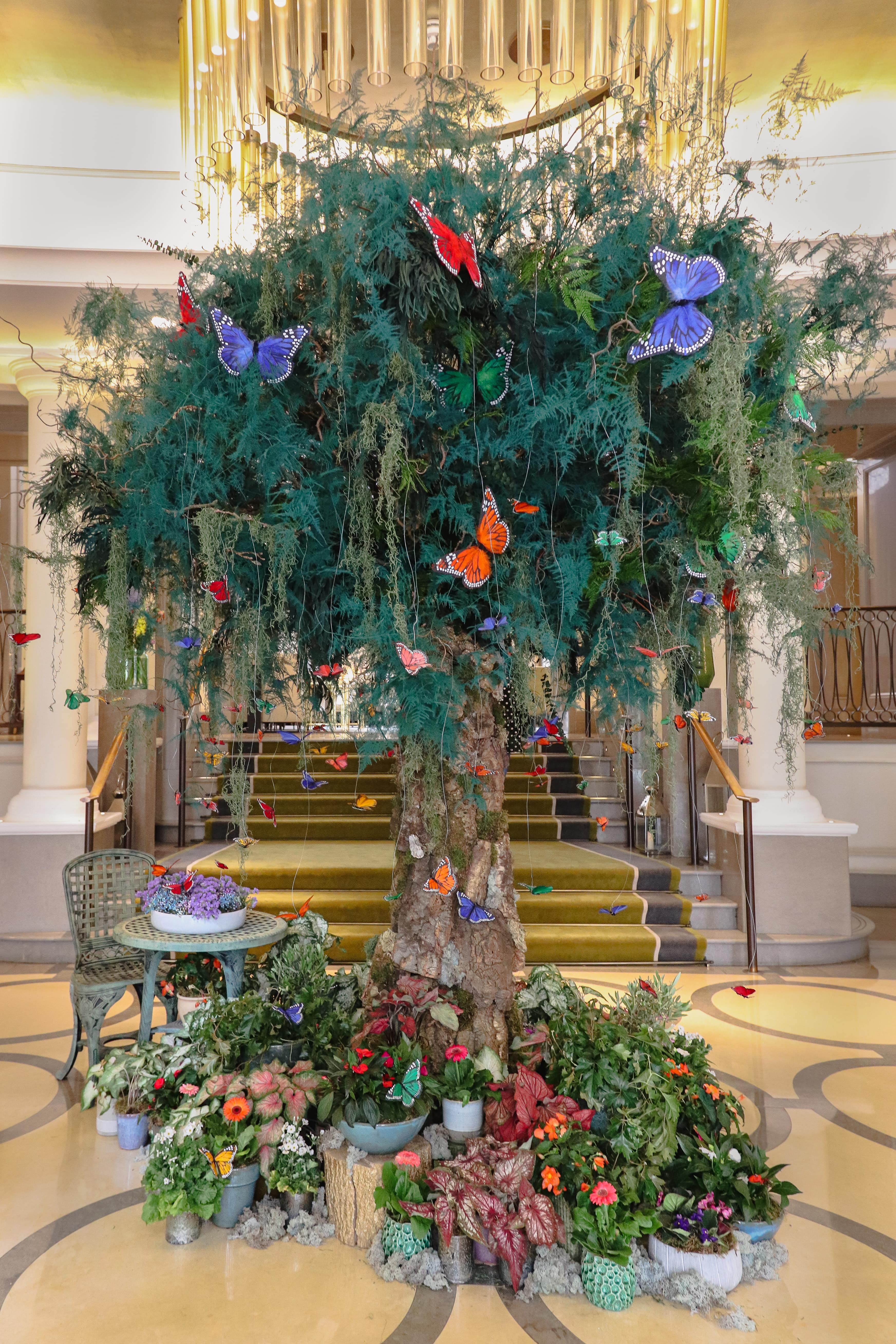 An indoor tree covered in colourful butterflies