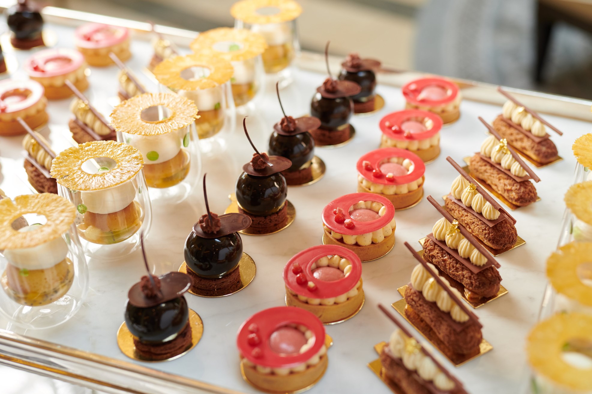 Afternoon tea trolley filled with assorted desserts, including pastries, cakes and scones, arranged on elegant trays