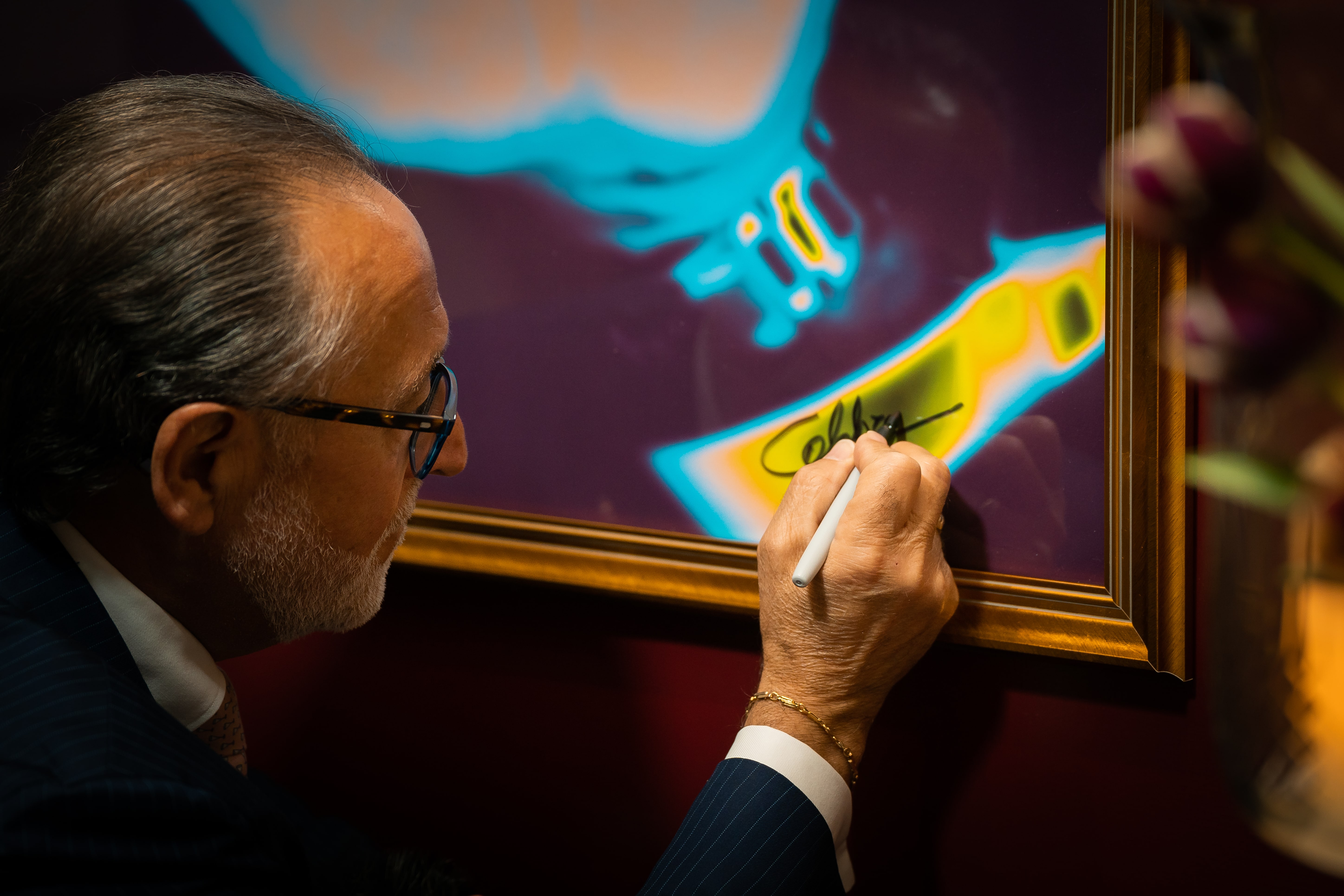 Renowned mixologist Salvatore Calabrese signing a promotional poster at Velvet Bar, part of the partnership with Corinthia London, highlighting expert cocktail craftsmanship