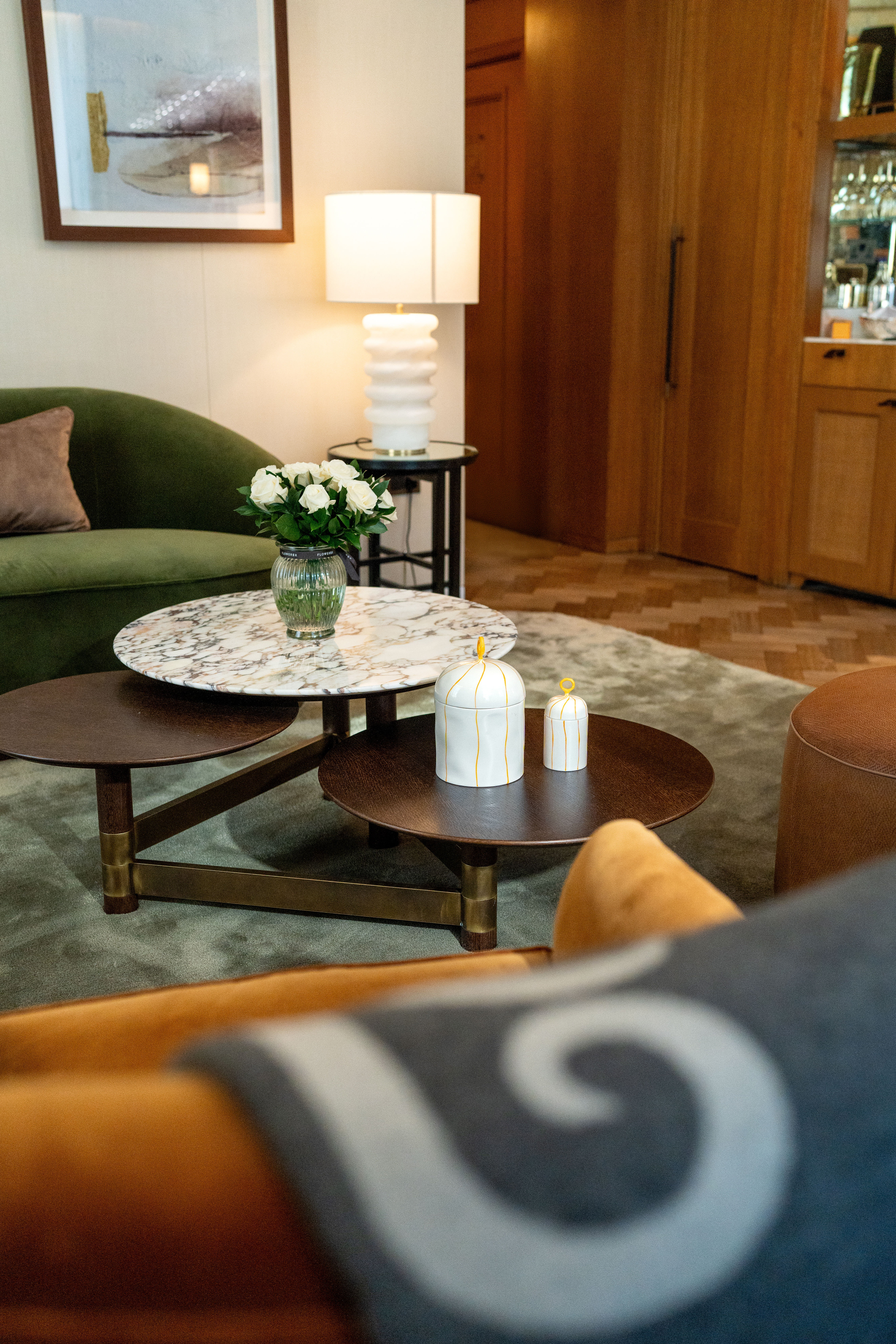 Array of luxury details in Corinthia Hotel London suites, including bespoke Feldspar candles, Begg & Co cashmere blankets, and FLOWERBX bouquets