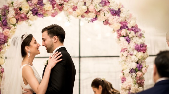 Wedding couple standing under a flower arch