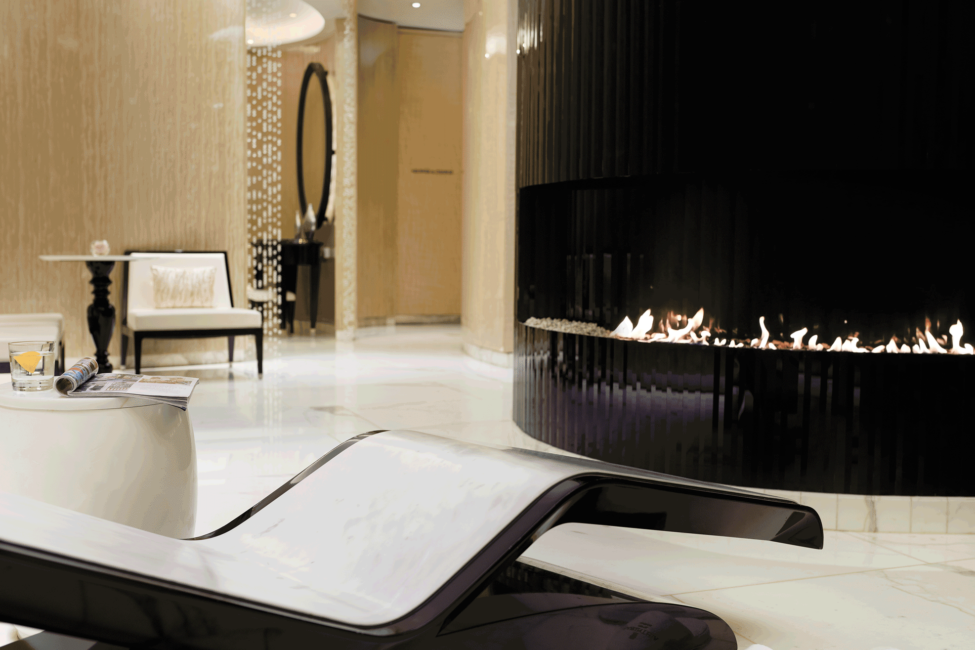 Soothing cinemagraph featuring marble heated lounger and glowing fireplace in changing room at ESPA Life at Corinthia spa near Trafalgar Square, London