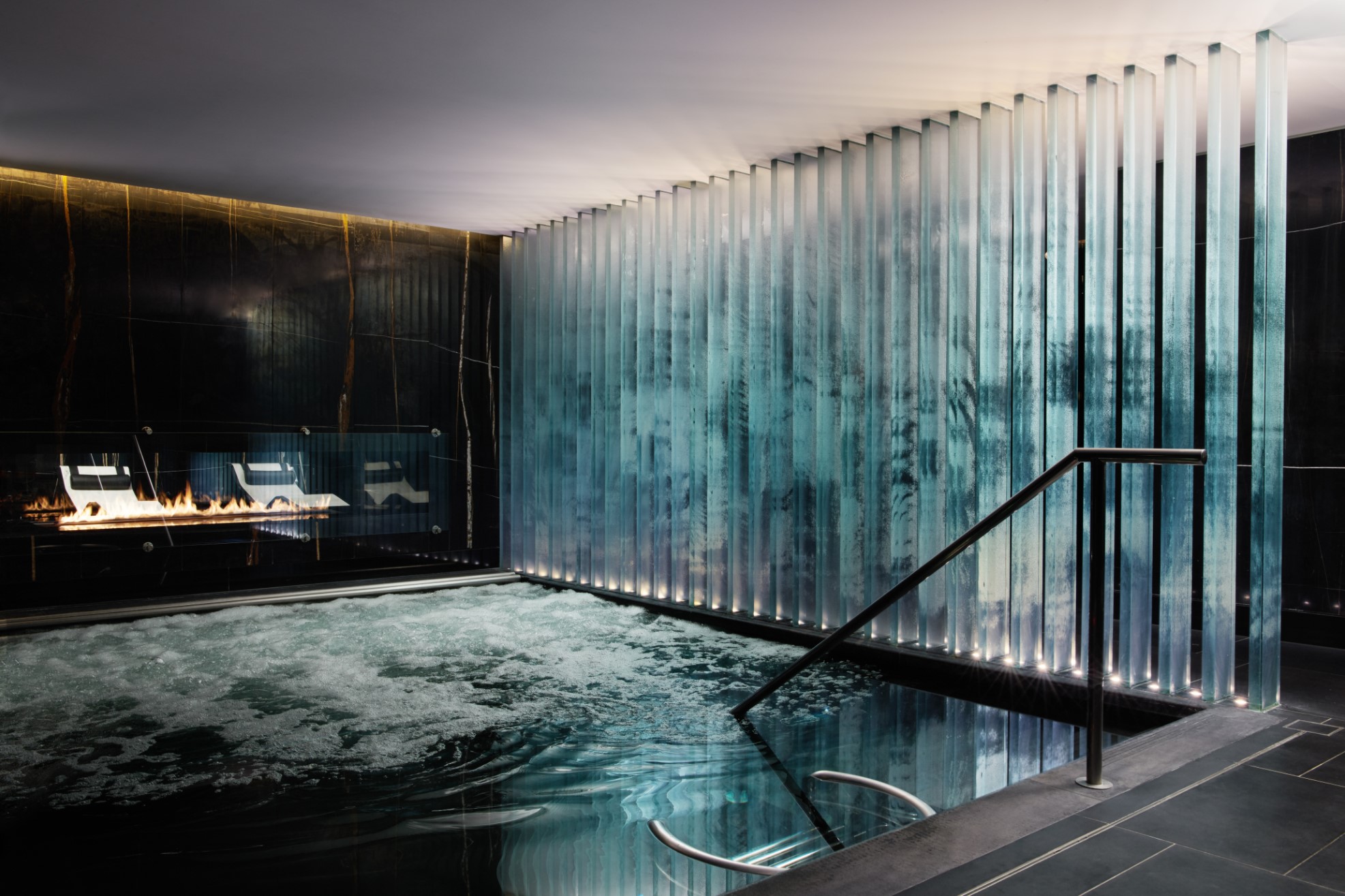 Relaxing vitality pool area with fireplace at Biome by Corinthia London luxury hotel spa near Trafalgar Square, London