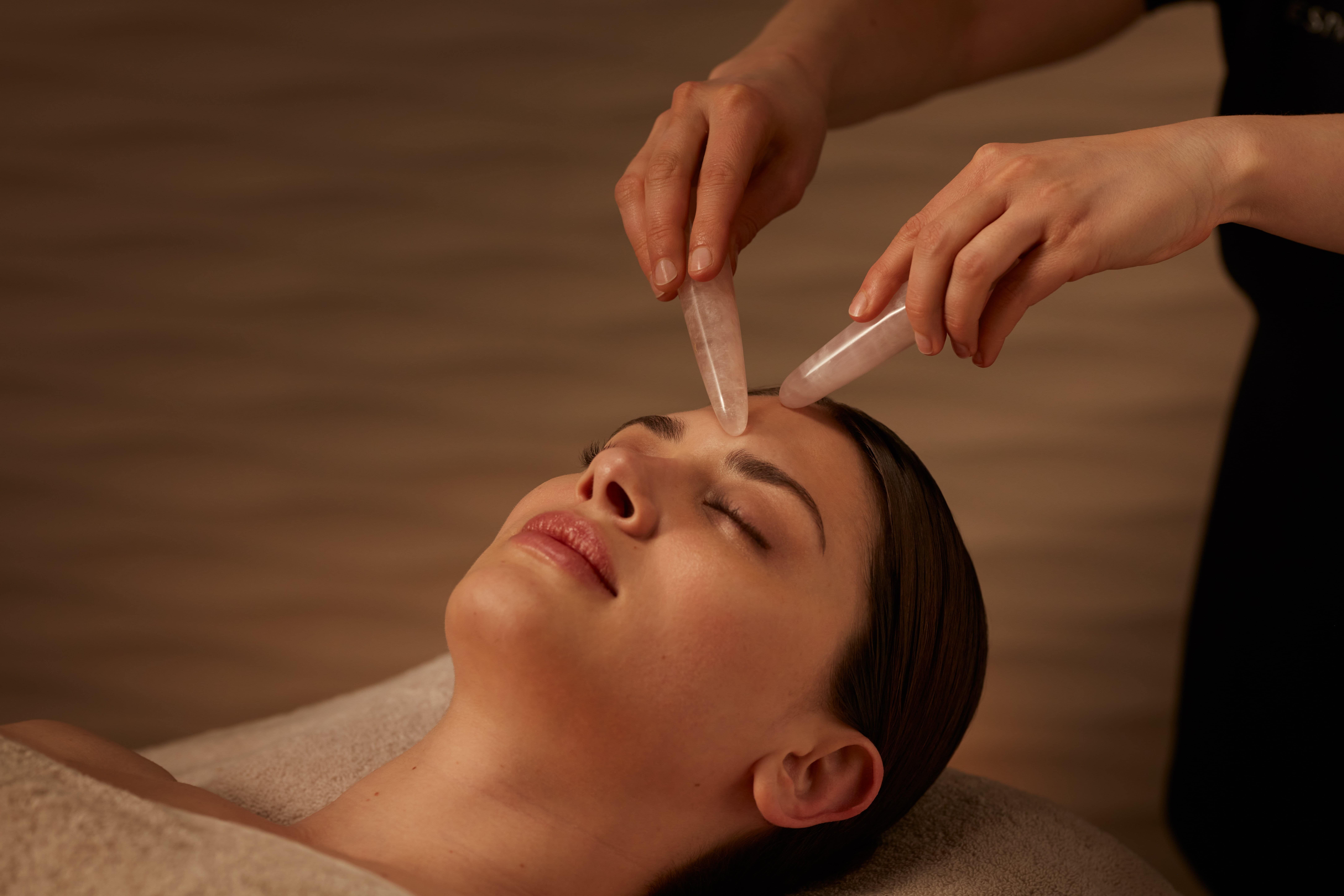 Healing crystal therapy with rose quartz performed by spa therapist on guest at ESPA Life at Corinthia luxury hotel spa in London