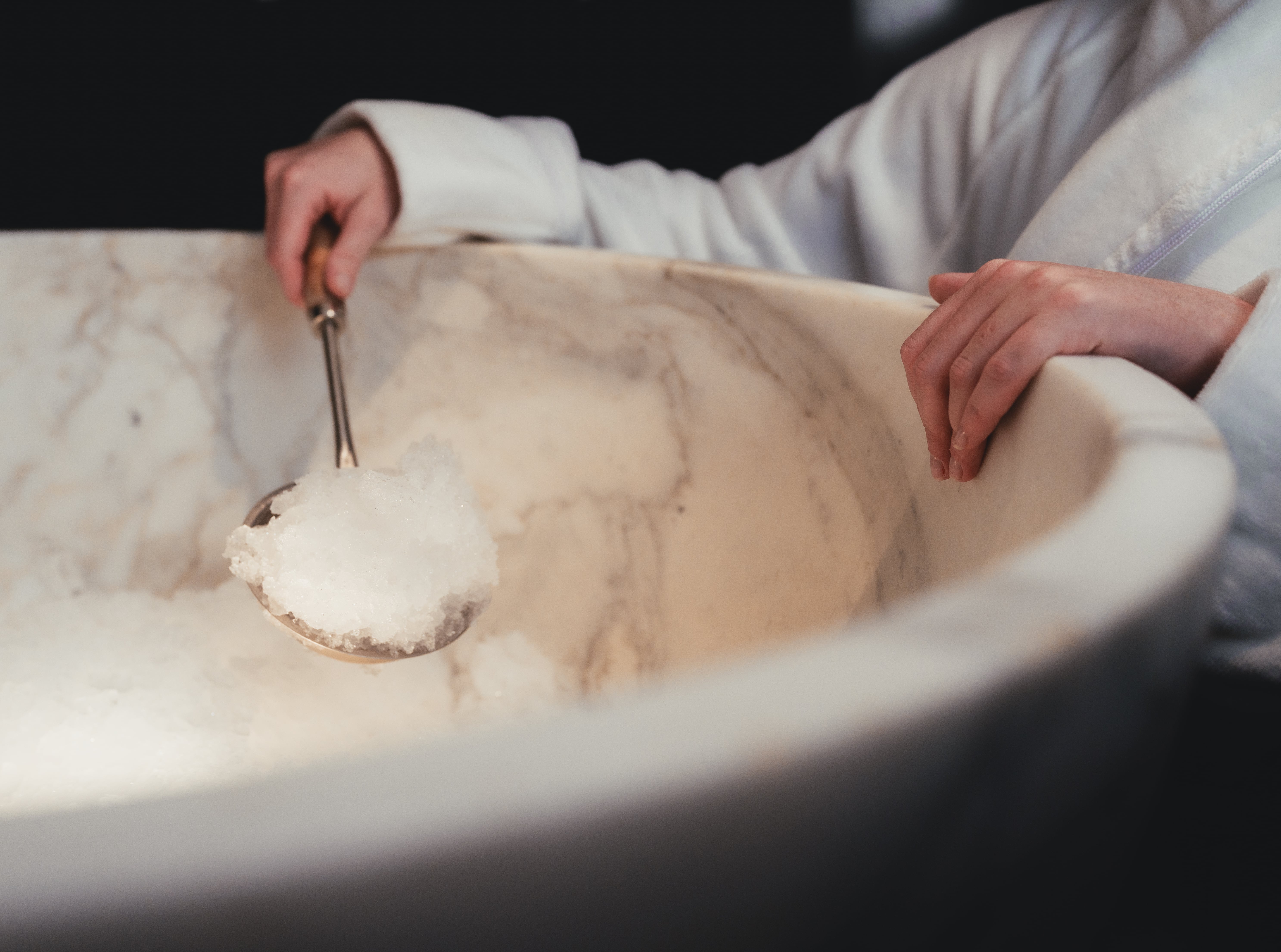 Spa guest enjoying the ice fountain in the thermal floor facilities at ESPA Life at Corinthia luxury hotel